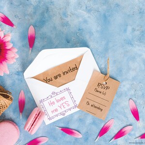 May include: An invitation scene with a pink gerbera daisy, pink petals, and macarons on a blue background. A white envelope contains a card that reads "You are invited." A brown tag reads "RSVP". A ball of twine is also present.