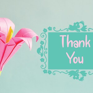 May include: A pink origami flower with a yellow center and green stem. The flower is set against a light blue background. A teal frame with the words "Thank You" in pink is on the right.