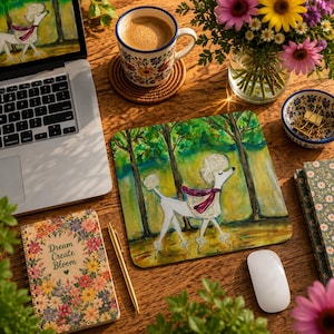 May include: A square mouse pad featuring a watercolor illustration of a white poodle wearing a magenta scarf walking through a forest. The mouse pad is placed on a wooden desk next to a laptop, a floral mug, a notebook with the text Dream Create Bloom, and a white mouse.