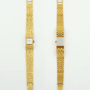 May include: Two gold-toned wristwatches. One watch features a square face with Roman numeral hour markers and a textured gold band. The other watch has a rectangular silver face and a gold band with a different textured pattern.