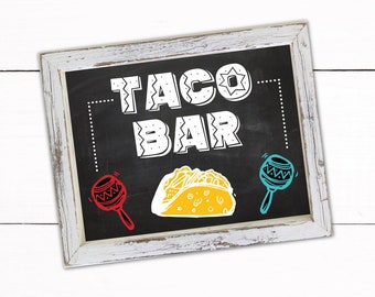 May include: A printable sign with a chalkboard background that says "Taco Bar" in white letters with a decorative border. The sign also features a yellow taco, a red maraca, and a blue maraca.