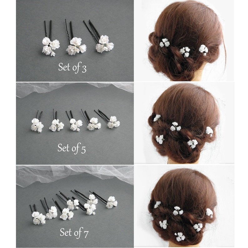 May include: Three sets of white flower hair pins. The first set has three pins, the second set has five pins, and the third set has seven pins. Each pin has a small cluster of white flowers.