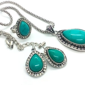 May include: A turquoise gemstone jewellery set with a necklace, ring, and earrings. The set features silver-toned metal with a teardrop-shaped design.
