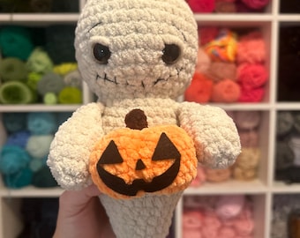 Puede incluir: Muñeco de fantasma de peluche hecho a mano con una calabaza. El fantasma es de color blanquecino con detalles negros cosidos para los ojos y la boca. La calabaza es naranja con una cara tallada. Un artículo temático de Halloween.