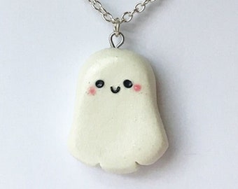 Op de afbeelding: Een witte spookketting met een glimlachend gezicht en roze wangen aan een zilveren ketting.