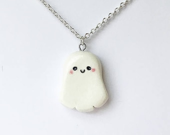 Op de afbeelding: Een zilveren ketting met een witte spookhanger. Het spook heeft een glimlachend gezicht met zwarte ogen en roze wangen.