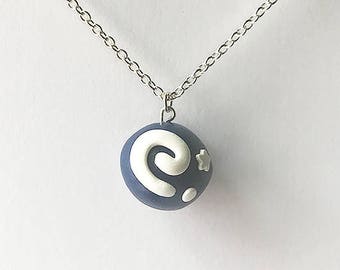 Op de afbeelding: Een zilveren ketting met een blauwe en witte hanger. De hanger is een bol met een wit swirl-ontwerp en een witte ster.