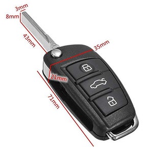 May include: A black car key fob with three buttons. The buttons are labeled with a lock, a car icon, and an unlock symbol. The key fob measures 7.1 cm long, 3.5 cm wide, and 2.1 cm thick.