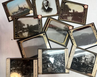 Op de afbeelding: Een verzameling antieke stereoscopische dia's met verschillende scènes. De dia's tonen een slagschip, een portret van een man, landschappen en scènes van de New Orleans Exposition. Elke dia is in een donker frame met tekst.