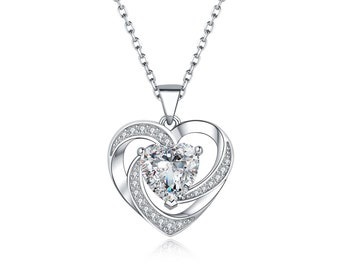 May include: A silver necklace with a heart-shaped pendant. The pendant features a large, clear, heart-shaped stone at its centre, encircled by smaller, clear stones. The necklace chain is also silver.