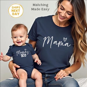 May include: Navy blue t-shirt with the word "Mama" and a heart graphic. A baby in a navy blue onesie with the words "Mama's Boy" is held by a person. The image includes the text "Matching Made Easy" and "SHIPS NEXT DAY".