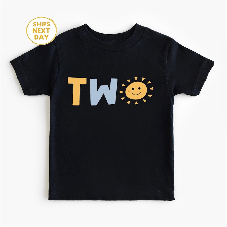 Puede incluir: Camiseta negra para ni&ntilde;o peque&ntilde;o con la palabra "TWO" en amarillo y azul claro, y un gr&aacute;fico de sol sonriente. El sol tiene rayos amarillos y una cara feliz. Un dise&ntilde;o sencillo para un segundo cumplea&ntilde;os.