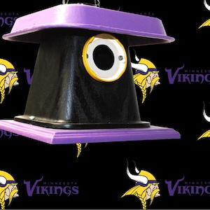 May include: A white ceramic mug with a black handle and the text "But First, Coffee" in a bold, black font. The mug is set against a blurred background, suggesting a cozy setting. The mug appears to be approximately 4 inches tall.