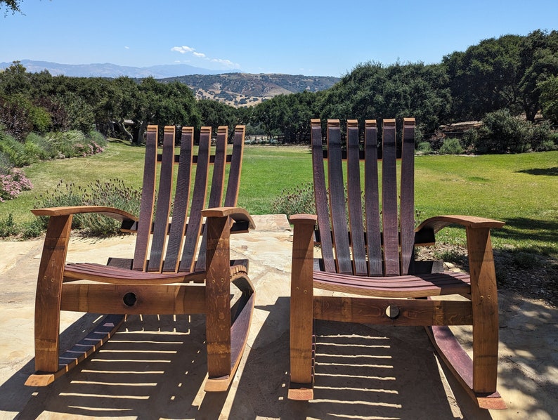 Repurposed Wine Barrel Rocking Chairs with dark red wine stain. The soft cradling Oak barrel Rocking chairs are coated with a protective oil that enhances the oak barrel colors.