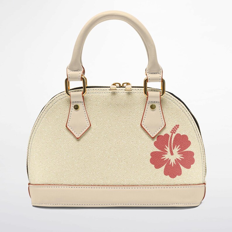 May include: Cream-colored dome handbag with a red hibiscus flower design. Features a cream-colored handle, trim, and gold-tone hardware. The bag has a textured surface and a black zipper.