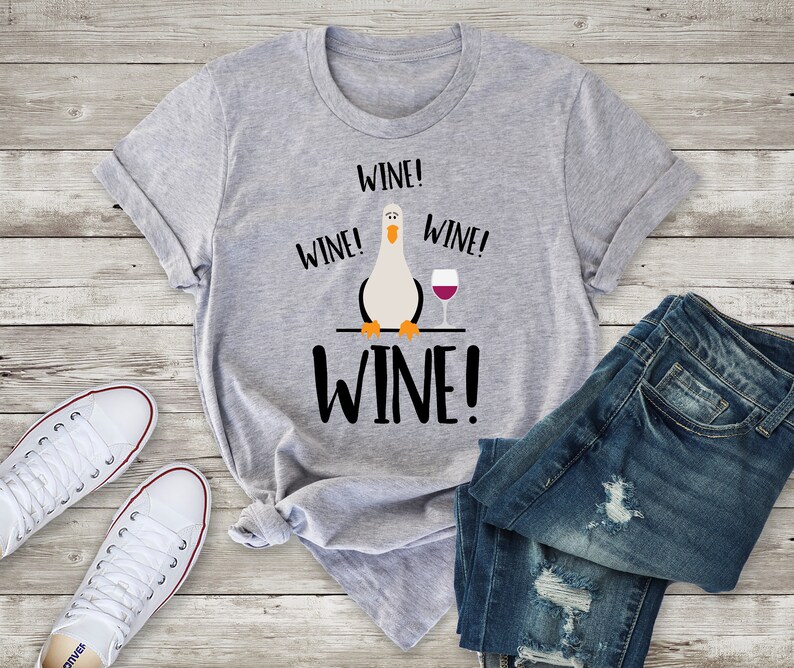 May include: Grey t-shirt with a cartoon bird and the text "Wine! Wine! Wine! Wine!" printed on it.