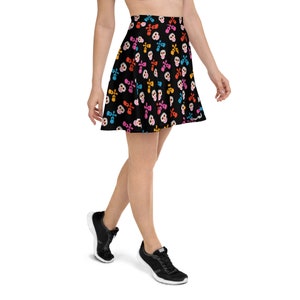 May include: A black skater skirt with a colorful skull pattern. The skirt is made of a soft, stretchy fabric and has a comfortable fit.