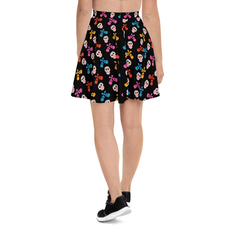 May include: A black skater skirt with a colorful skull and crossbones pattern. The skirt is knee-length and has a flared silhouette.