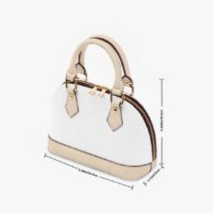 May include: White dome-shaped handbag with beige trim and handles. The bag features a gold zipper and hardware. Dimensions are approximately 9.65 inches (24.5 cm) wide, 7.09 inches (18 cm) high, and 4.72 inches (12 cm) deep.