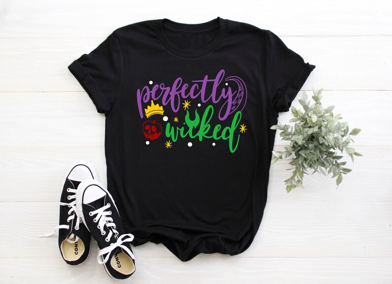 May include: Black t-shirt with a purple and green graphic that says "perfectly wicked" with a crown, apple, and crescent moon design.