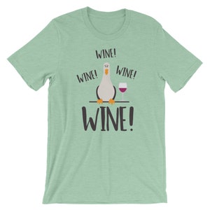 May include: A light green t-shirt featuring a cartoon seagull and the text "WINE!" repeated four times.