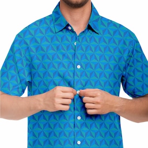May include: A blue and green short-sleeved button-down shirt with a geometric pattern.