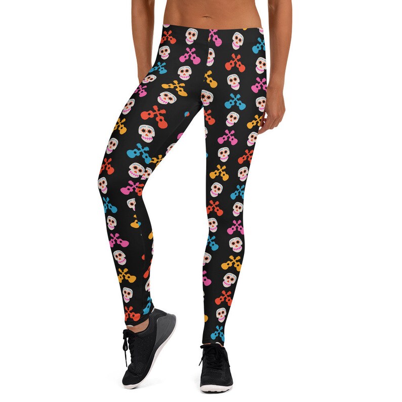 May include: Black leggings with a colorful skull and guitar pattern. The pattern features skulls with sunglasses and guitars in pink, blue, orange, and yellow.