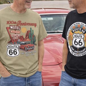Puede incluir: Dos camisetas con gr&aacute;ficos de la Ruta 66. Una es verde oliva con un letrero de motel, un coche cl&aacute;sico y el texto "100th Anniversary". La otra es negra con un emblema de la Ruta 66 y el texto "100th Anniversary The Mother Road."