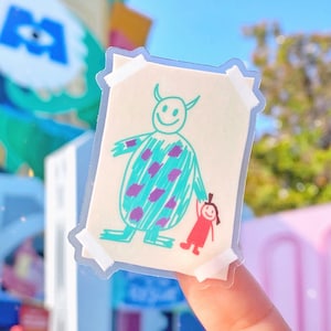 May include: A clear sticker with a drawing of a blue monster with purple spots holding the hand of a small red girl. The drawing is on a white background and has a white border.