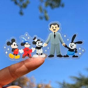 May include: A clear sticker sheet with five cartoon characters. The characters are Mickey Mouse, a magician Mickey Mouse, a black and white Mickey Mouse, Walt Disney, and Oswald the Lucky Rabbit. The characters are all holding hands and smiling.
