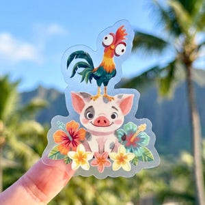 May include: A clear sticker featuring a cartoon pig with a smiling face, surrounded by colorful flowers. A rooster with a red comb and green tail is perched on the pig's head. The background shows a blue sky and palm trees.