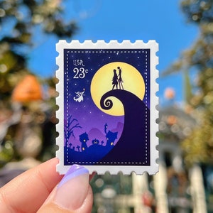May include: A purple and yellow postage stamp with a silhouette of Jack Skellington and Sally from the Nightmare Before Christmas movie. The stamp says "USA 23c" in the top left corner.