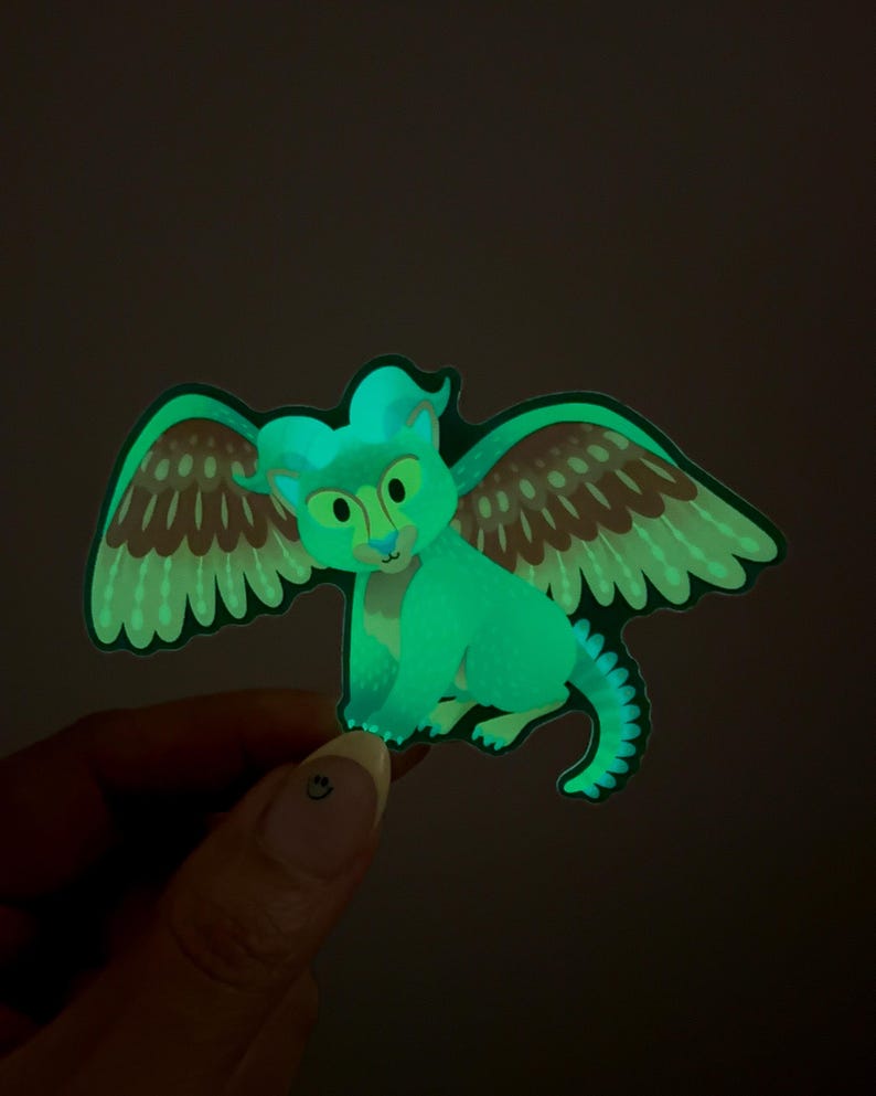 Peut inclure: Un autocollant vert qui brille dans le noir repr&eacute;sentant une cr&eacute;ature ail&eacute;e avec des ailes brunes et vertes. La cr&eacute;ature a une t&ecirc;te bleu clair et un visage jaune.