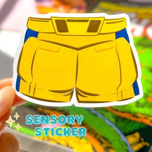 May include: A yellow and blue sensory sticker featuring a pair of denim shorts with a belt. The sticker says "SENSORY STICKER" at the bottom.