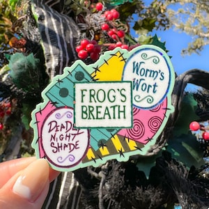 May include: A colorful sticker with a patchwork design featuring the text "Frog's Breath", "Worm's Wort", and "Deadly Nightshade".