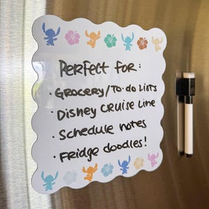 May include: White, scalloped-edge dry-erase board with Stitch and flower graphics. Text reads "Perfect for: Grocery/To-do Lists, Disney Cruise Line, Schedule notes, Fridge doodles!" A black and white marker is attached.