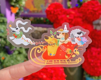 May include: A clear sticker featuring a festive scene with cartoon dogs in a red sleigh. The sleigh is pulled by a ghost dog wearing a Christmas wreath. Other dogs are in the sleigh, with Christmas trees and a bottle on their heads. The background is blurred.