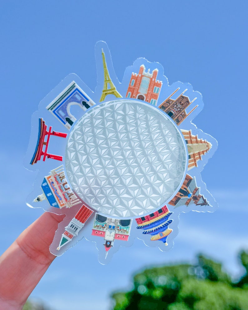 May include: A clear sticker with a white geodesic dome in the center surrounded by colorful illustrations of famous landmarks from around the world, including the Eiffel Tower, the Taj Mahal, and the Great Wall of China.