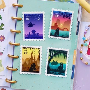 May include: Four colourful postage stamps featuring silhouettes of Disney couples from different animated films. The stamps are arranged in a grid on a light blue background with a white star pattern. The stamps feature the text "USA 23&cent;".