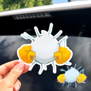 May include: White and yellow cartoon sticker featuring a white sphere with yellow hands breaking through a blue and white cracked surface. A smaller version of the sticker is also visible.