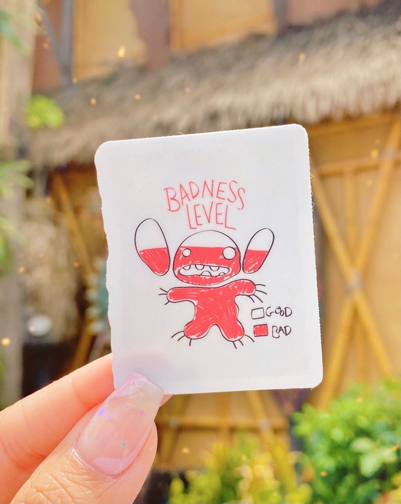 Puede incluir: Una pegatina blanca con un personaje de dibujos animados rojo y el texto "Badness Level". El personaje tiene ojos grandes y una boca ancha. Hay dos casillas debajo del personaje, una etiquetada como "Good" y la otra como "Bad".