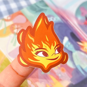 May include: A sticker of a cartoon fire character with a yellow face, orange hair, and a friendly smile. The character is wearing a red and orange outfit.
