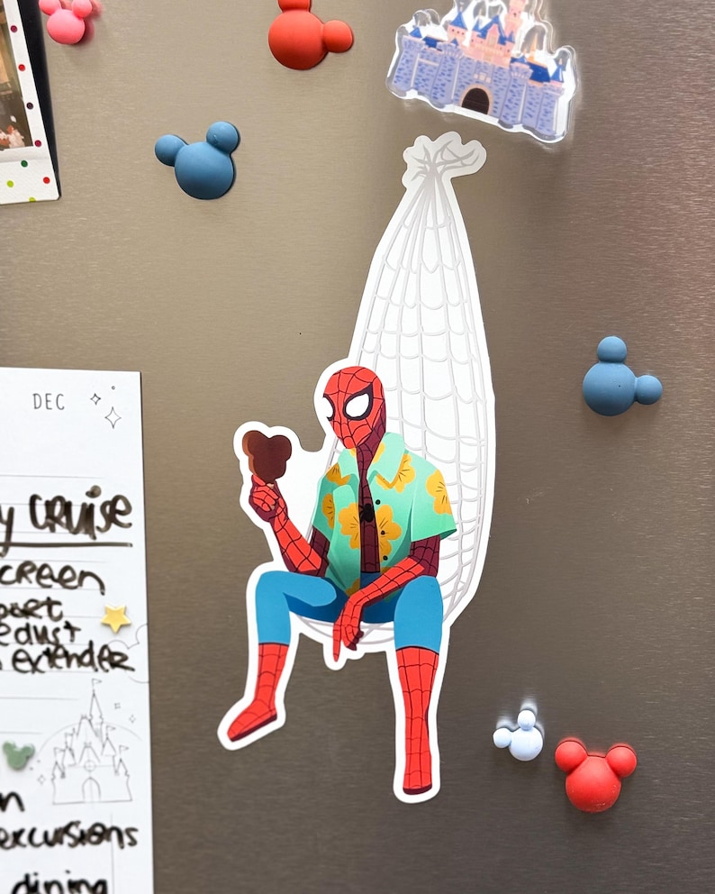 May include: A Spider-Man sticker wearing a Hawaiian shirt and blue pants, holding a chocolate ice cream bar, seated in a white web-like chair. Surrounding the sticker are Mickey Mouse-shaped magnets and a Disney castle magnet.