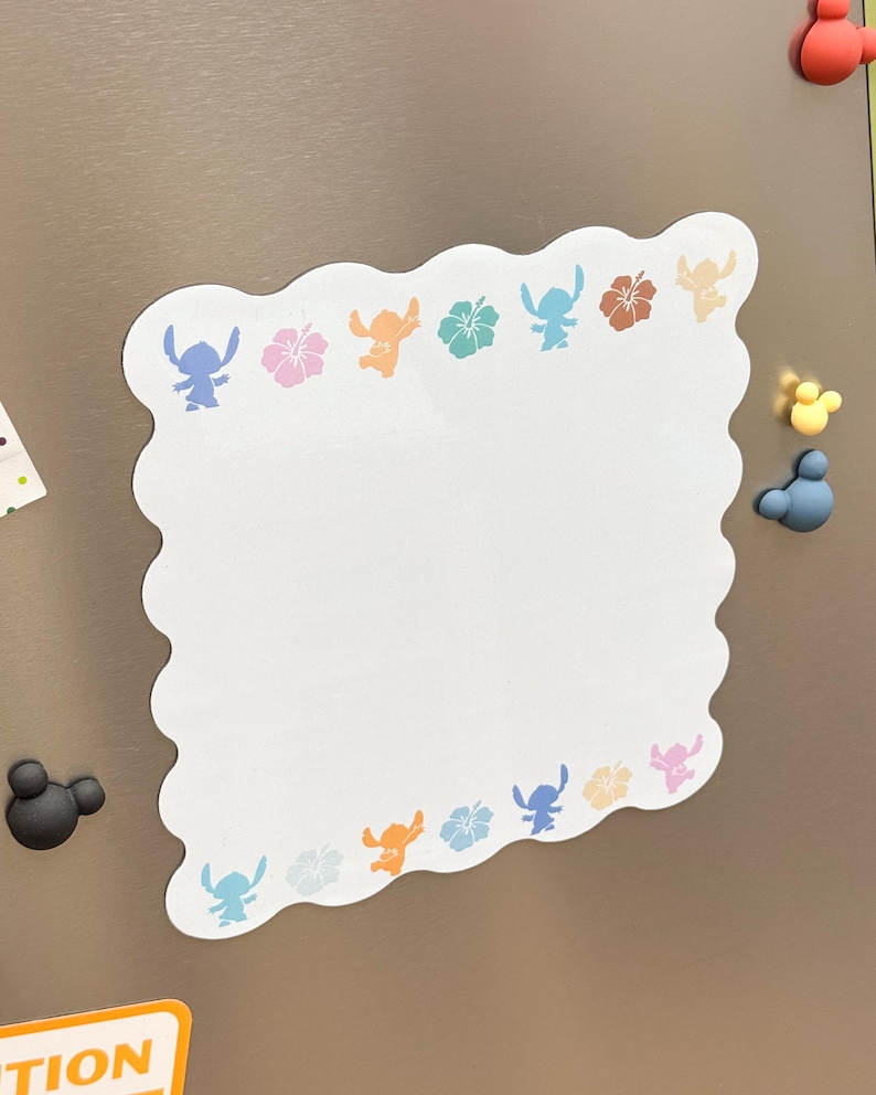 May include: White, scalloped-edge memo board with colorful Stitch and flower designs. The board has a blank center for notes and is decorated with blue, pink, orange, and brown graphics. Magnetic Mickey Mouse shapes are on the right and left.