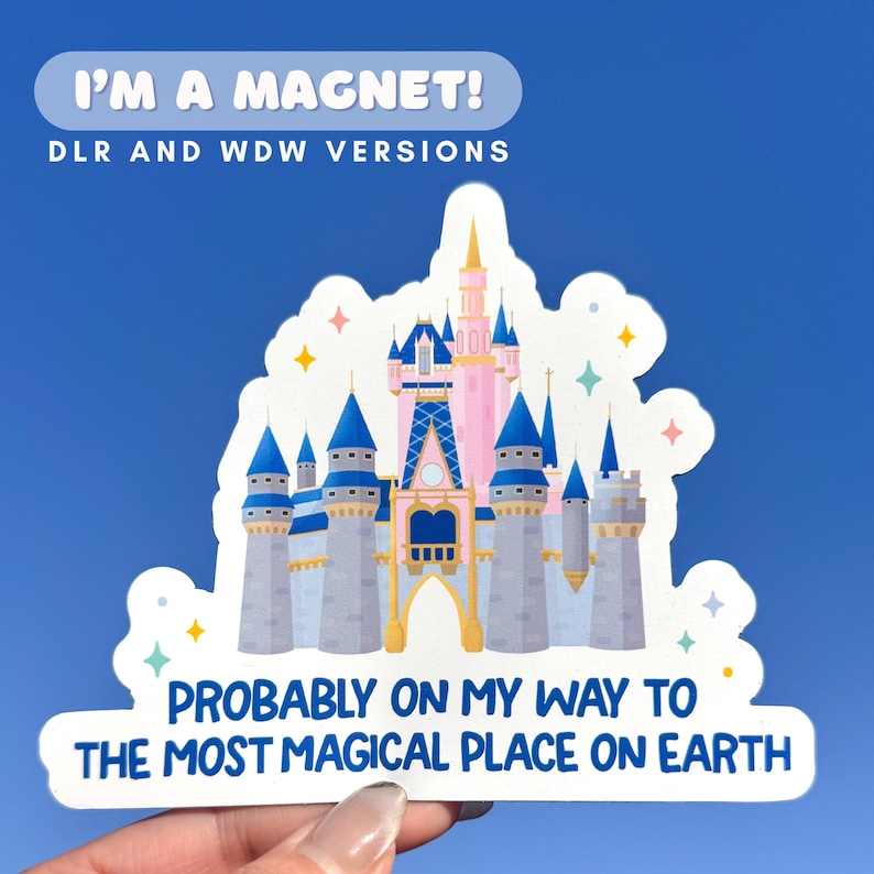 May include: A white magnet with a colorful illustration of a fairytale castle. The magnet has text that reads "I'M A MAGNET!" and "PROBABLY ON MY WAY TO THE MOST MAGICAL PLACE ON EARTH."