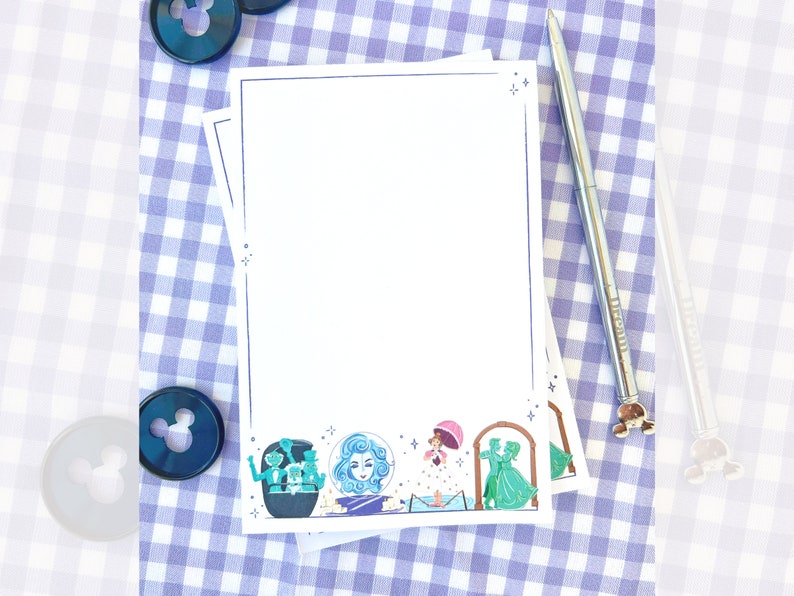 Puede incluir: Una pila de blocs de notas blancos en blanco con un fondo de cuadros azules y blancos. Los blocs de notas tienen un borde decorativo con una ilustraci&oacute;n caprichosa de personajes de una pel&iacute;cula de Disney. La ilustraci&oacute;n incluye una mujer con el pelo largo, un hombre con un traje verde y una mujer con un vestido rosa.