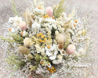 May include: A bouquet of dried flowers in shades of white, cream, and yellow. The bouquet includes small white flowers, dried grasses, and a few pink flowers.