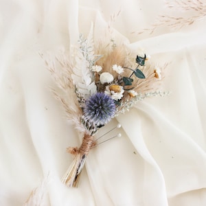 Boutonnière de cardo azul empolvado / Vegetación de eucalipto con un toque de flores secas en tonos neutros.