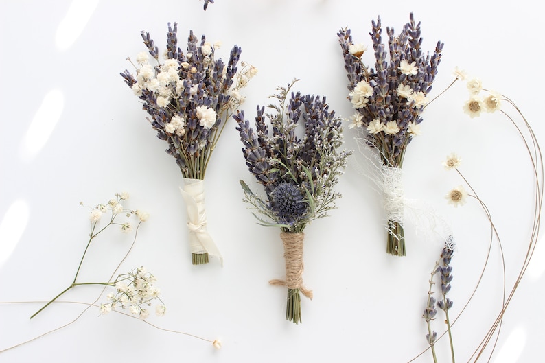 May include: Three small bouquets of dried lavender, baby's breath, and other dried flowers tied with twine and ribbon.