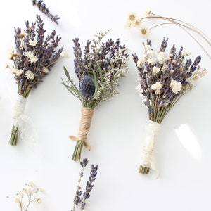 May include: Three small bouquets of dried lavender, white baby's breath, and other dried flowers tied with twine and ribbon.